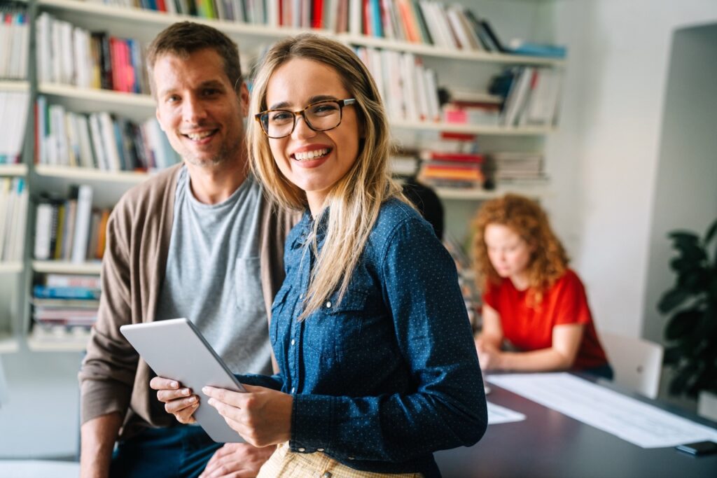 Spotkanie po konsultacji — uczestnicy uśmiechają się, trzymając tablet.